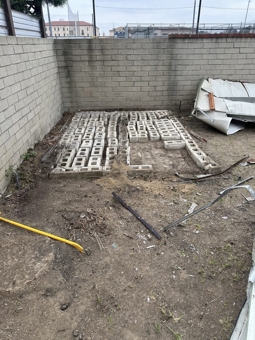 After: green metal shed removed down to the cinder block foundation in Seal Beach, California