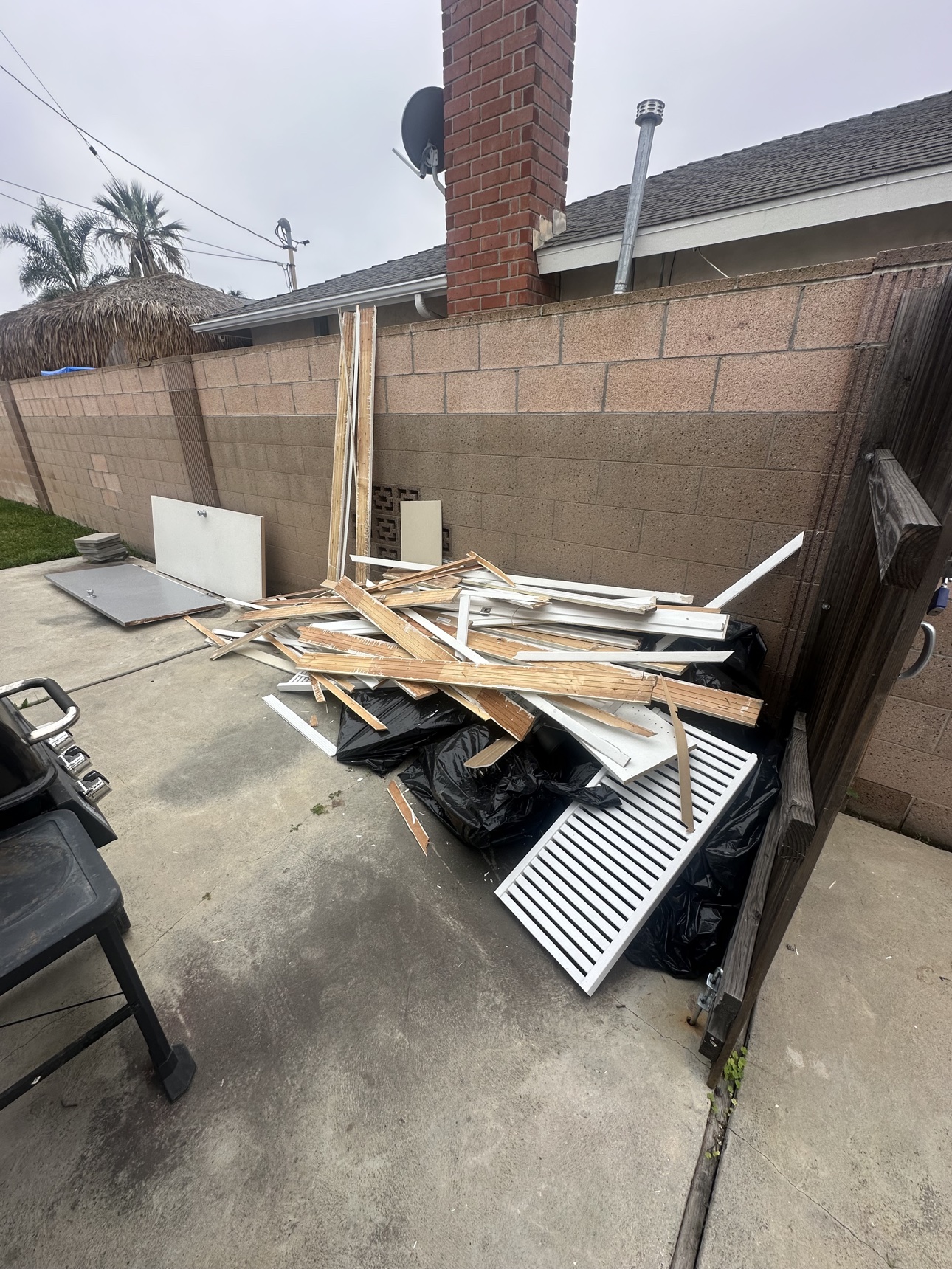 Before: doors, lumber and renovation trim piled on a Garden Grove backyard patio