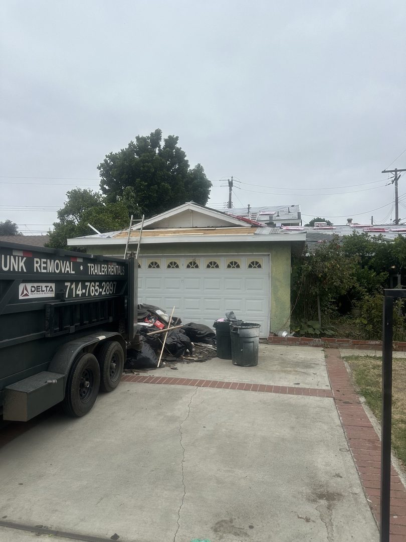 Delta trailer mid-haul at a trash pile by the garage in Stanton, California
