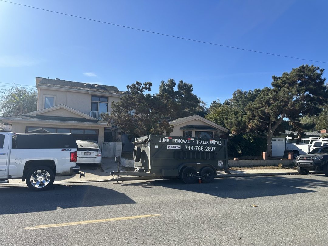 Delta dump trailer with junk removal and trailer rental branding dropped on a Newport Beach, California street