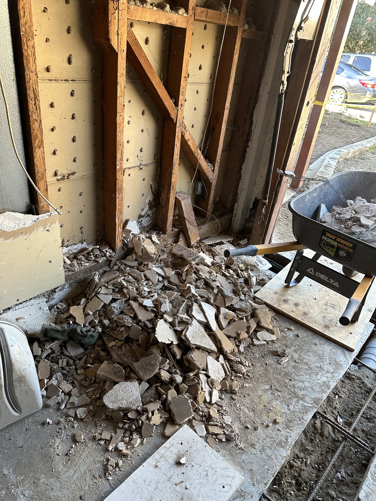 Delta-branded wheelbarrow beside debris during a Riverside cleanup